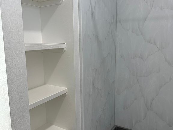 Storage next to shower. Shower has solid surface walls and shower pan/floors installed.