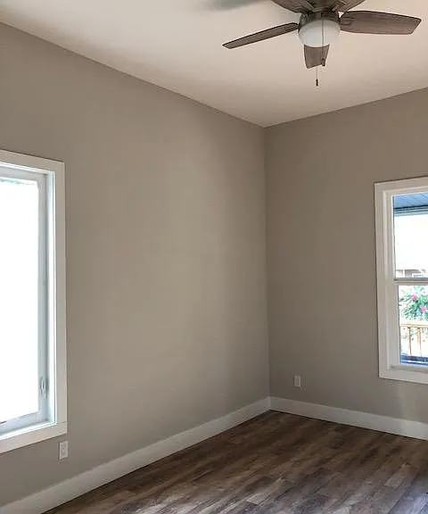 Front bedrooom faces the front porch, has wood laminate floors, decorator two tone paint, ample natural light through two large windows, ceiling fan