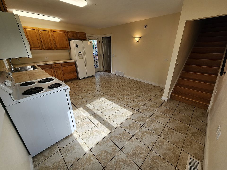 Upstairs is a large living space. The main bedroom is through the door by the refrigerator and has an ensuite bathroom.