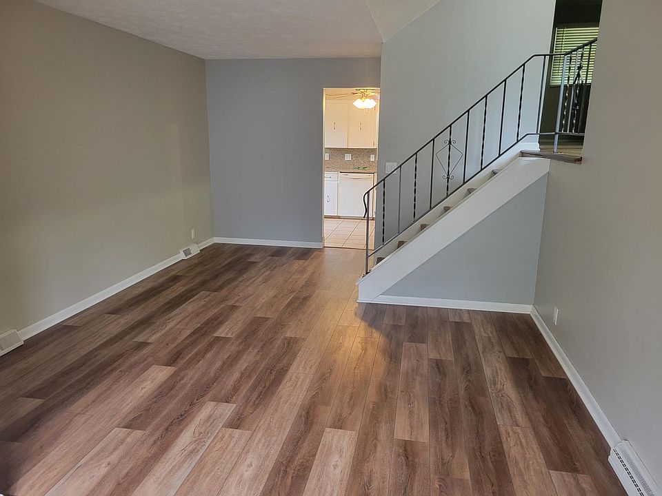 Front room, stairs to upstairs, and kitchen entry.