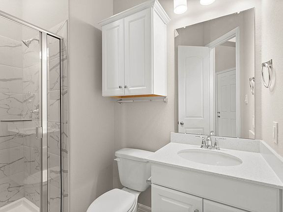The secondary bath features tile flooring, white cabinetry and light countertops and an oversized sh