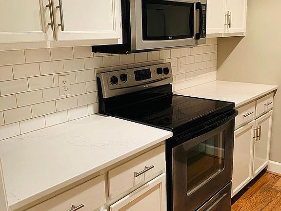 New subway tile backsplash, granite countertops, and refinished cabinets