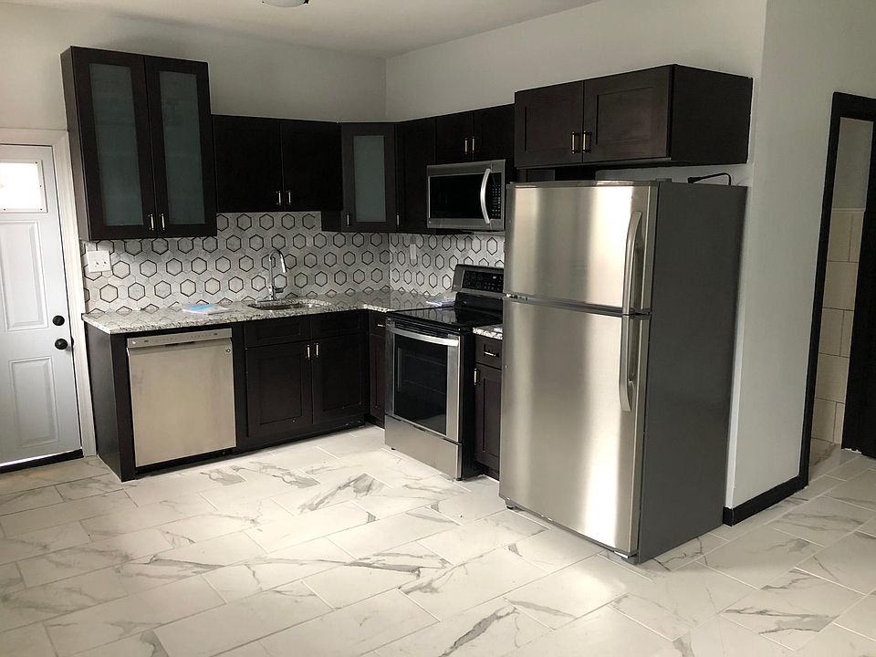Kitchen with door that leads to private patio. Brand new fridge, oven, dishwasher, and microwave .