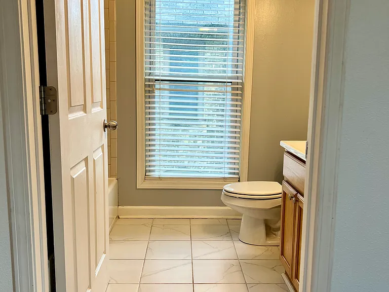 Primary bathroom with tons of light. both bathrooms have showers over a tub and medicine cabinet storage mirrors