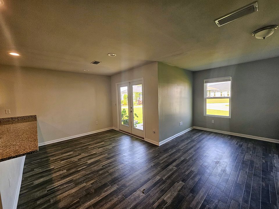 View from kitchen counter to dining area, with french doors opening to the back porch and large corner lot back yard