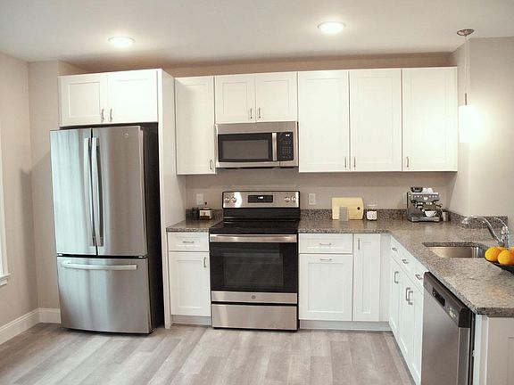 Shaker White Kitchen Cabinets with Granite Counter Tops and French Door Refrigerator