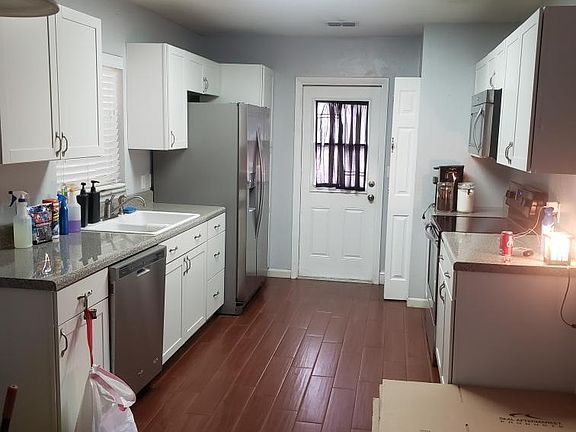 Kitchen with pantry cabinet across from broom, vacuum, and large pan closet. Side by side refrigerator with ice and water in the door. Dishwasher with over the stove microwave.
