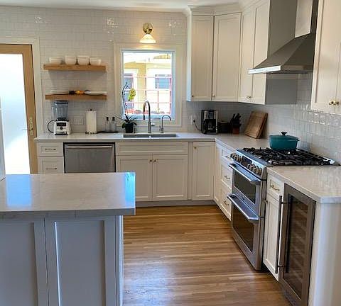 GE Cafe stove/double oven and hood next to wine fridge