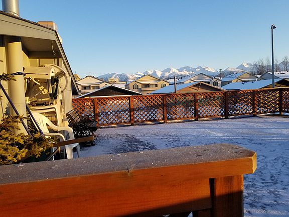 Large enclosed deck with tables, seating and awesome view of the Chugach Mountains while looking East.