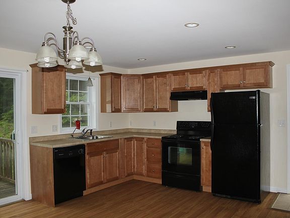 Kitchen cabinets, appliances, slider to back deck, side door to driveway.