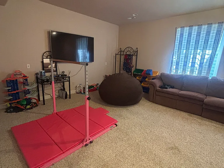 Basement living room with 65" smart tv and Lazy Boy sectional.