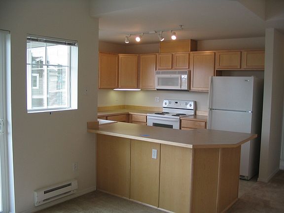 View of kitchen from Living room. Door to Patio on Left Side