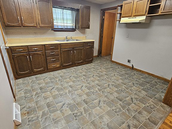 Kitchen, doorway in far corner leads downstairs to basement. Doorway on lefthand wall opens to garage