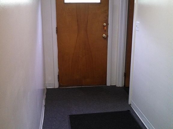 Looking at rear entrance door from inside hall way. bath to