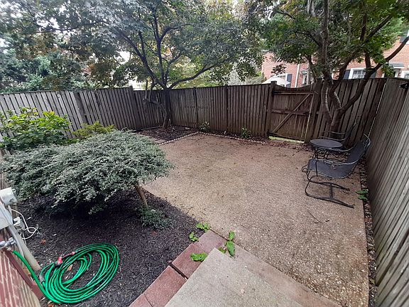 Life is good: Patio : seen from Kitchen door to interior fenced garden, two trees, flower beds, it allows three seasons gatherings for up to 10 people. Exterior garden door allows access to a large communal garden in the back for children to play.