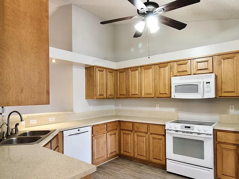 U-shaped kitchen with ample wood cabinetry, generous counter space, and a full appliance package for easy meal prep.