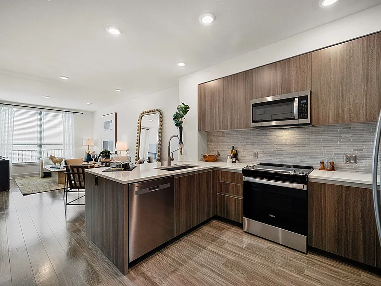 Open kitchen with quartz counters and ample modern cabinetry