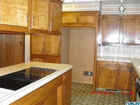 Tile counters, Jennaire 6 burner cooktop, custom wood cabinets