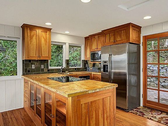 Fully updated kitchen in 2008 with stainless appliances, tile counters, new cabinets, and door to ba