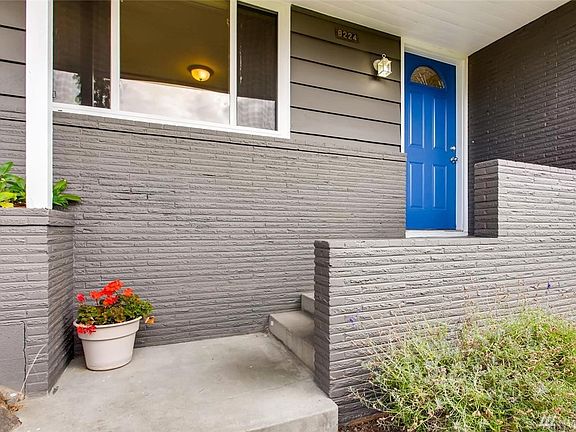 Classic mid-century rambler with built-in Roman Brick planter boxes and cheerful porch and entry.