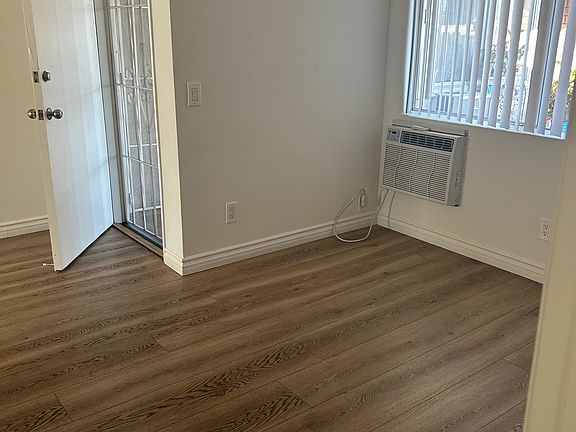 Unit 5 living room, facing toward front door and AC and window.
