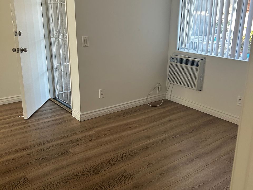 Unit 5 living room, facing toward front door and AC and window.