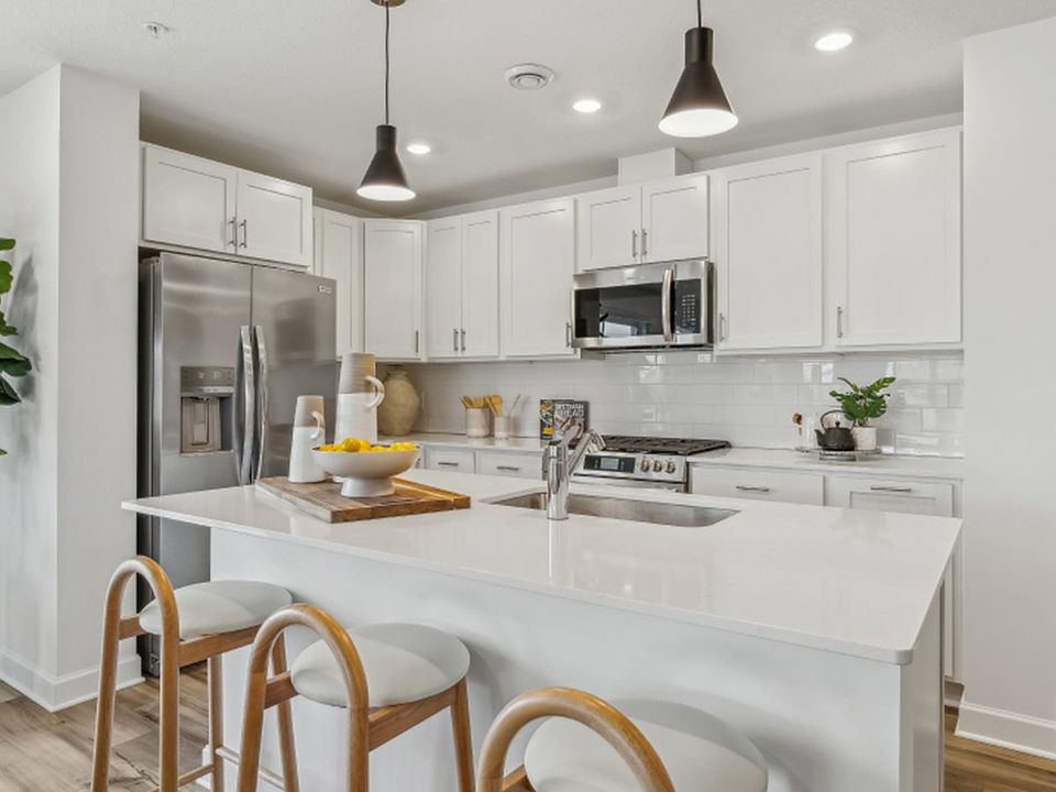 The stylish kitchen comes equipped with popular features like a brand-new GE_ appliance package, quartz countertops and a center island that doubles as a breakfast bar.