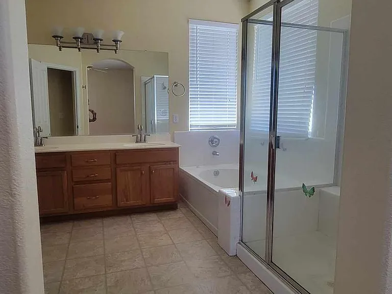 Master bathroom has open layout with bedroom, includes separate large tub and spacious, enclosed shower
