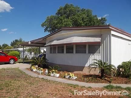 Front view : Large two car carport is to the left of photo