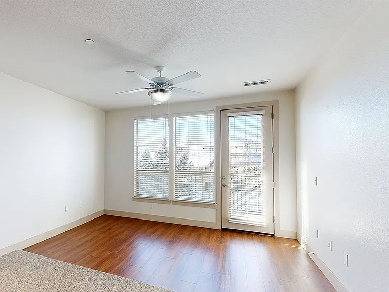Apartment dining and living room with wood-style flooring.