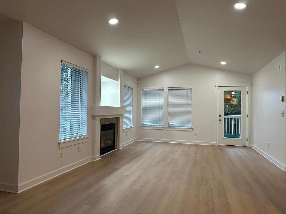 Living room area with recessed lights and new luxury LVP flooring. Includes access to private balcony. Faces south and is well-lit during the day