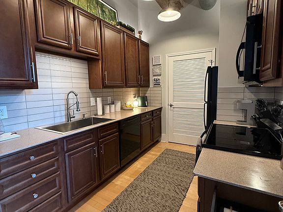 Kitchen features tiled backsplash and wifi-connected lighting underneath and above the cabinets for optimal lighting.