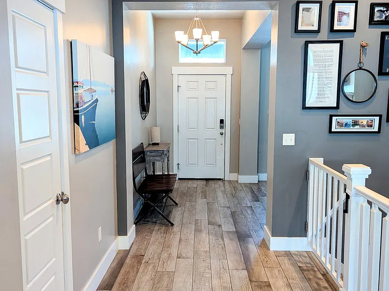 Entryway from front door, staircase (right) going downstairs to walk out lower-level. Coat or broom closet to the left.