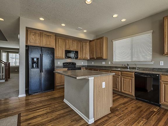 Large designer kitchen w center island- it is part of a great room floor plan- with glass doors to an outside patio and huge 1/3 acre professionally landscaped private yard