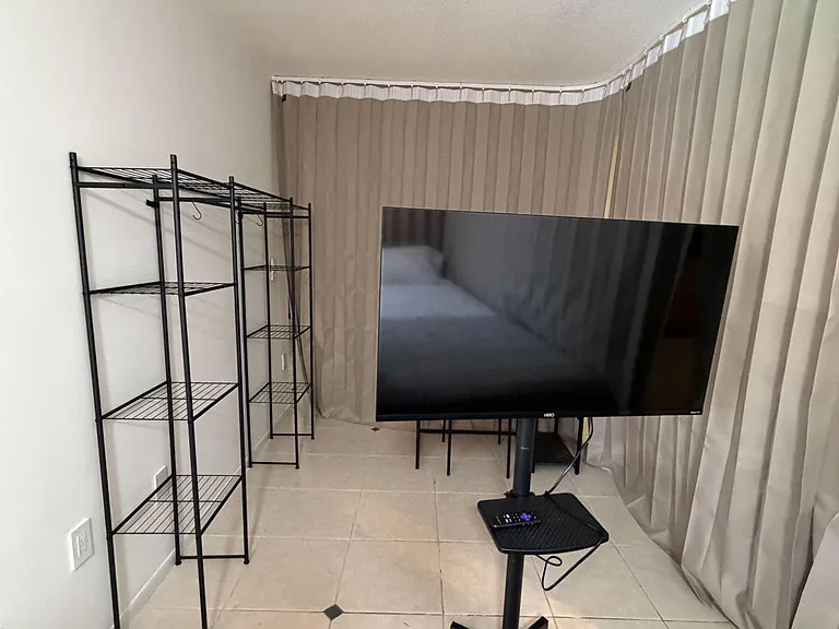 Multi-use room with tiled floors, full window coverings, and open shelving for convenient storage and organization.