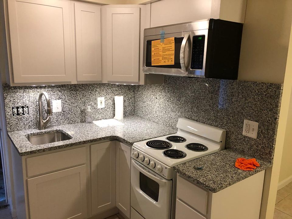 Kitchen with Granite Counter Tops and motion sensor under counter lights, New microwave, counter and cabinets.