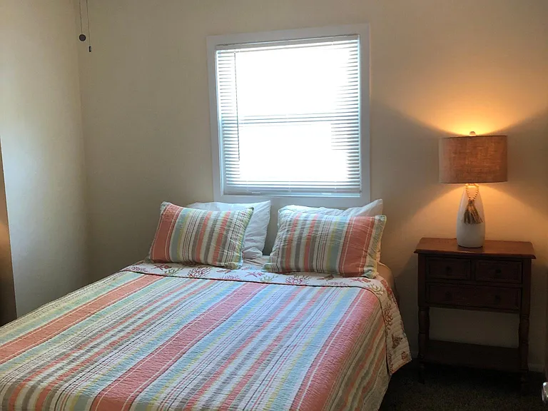 Master bedroom with Queen bed, dresser with mirror, ceiling fan and walk-in closet, and towel rack.
