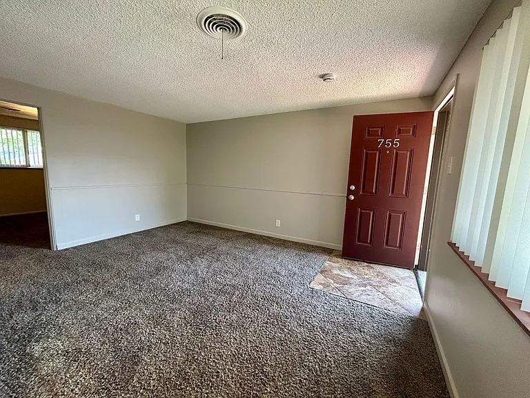 Inviting living space with plush carpeting, neutral walls, and natural light streaming through large windows, enhancing the cozy ambiance. Inviting living space with plush carpeting, neutral walls, and natural light streaming through large windows, enhanc