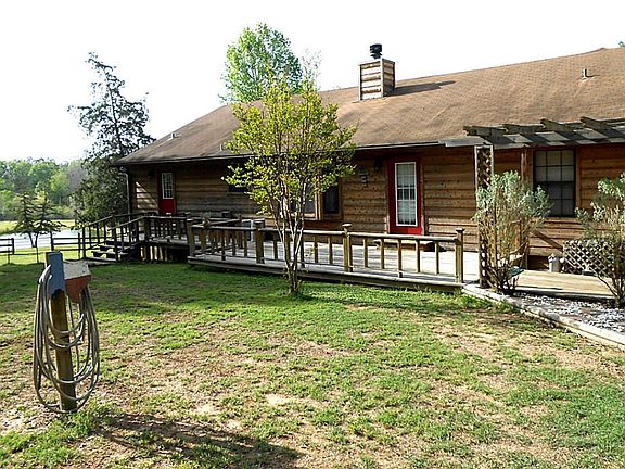Back side of home, see pond in distance. Door at left has "doggy door" exit from laundry/utility roo