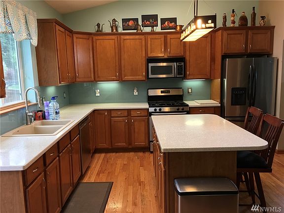 Wonderful kitchen with large island, solid surface countertops, Blanco sink, glass backsplash, quality cabinetry, and real wood floors.French door refrigerator.