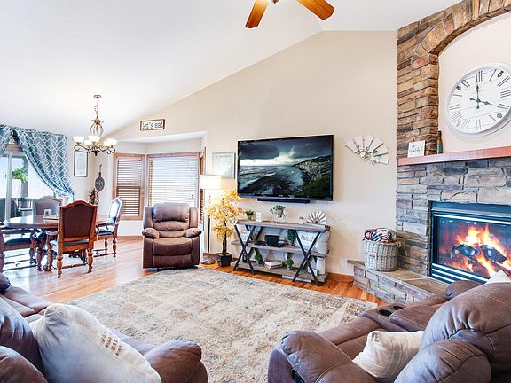 Great Room with Vaulted Ceiling, Gas Fireplace, Ceiling Fan, and Genuine Hardwood Flooring