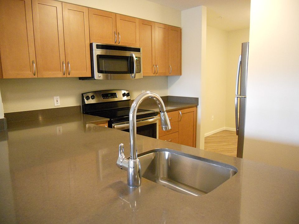 Renovated kitchen features sparkling quartz counters & stain