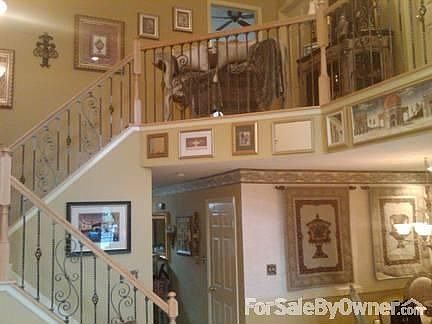 Livingroom view looking to 2nd floor : Rod-iron spindels on staircase. Designer touches and quality 