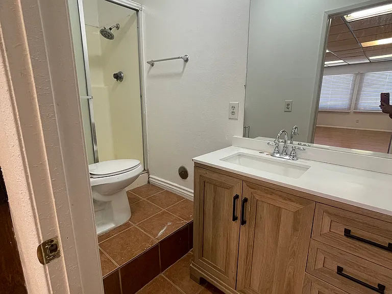 Common area bathroom. Totally remodeled. New counter, sink, faucet, cabinets, mirror, toilet, tile, shower, paint.
