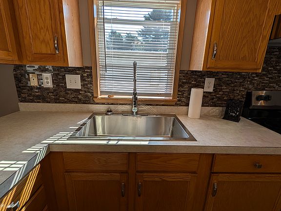 Large bowl sink with commercial faucet and window above sink