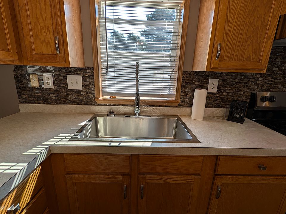 Large bowl sink with commercial faucet and window above sink