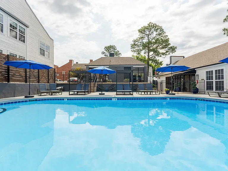 A sparkling swimmin gpool with sundeck and tandem chaise lounge chairs is shown at ReNew on Cantrell.