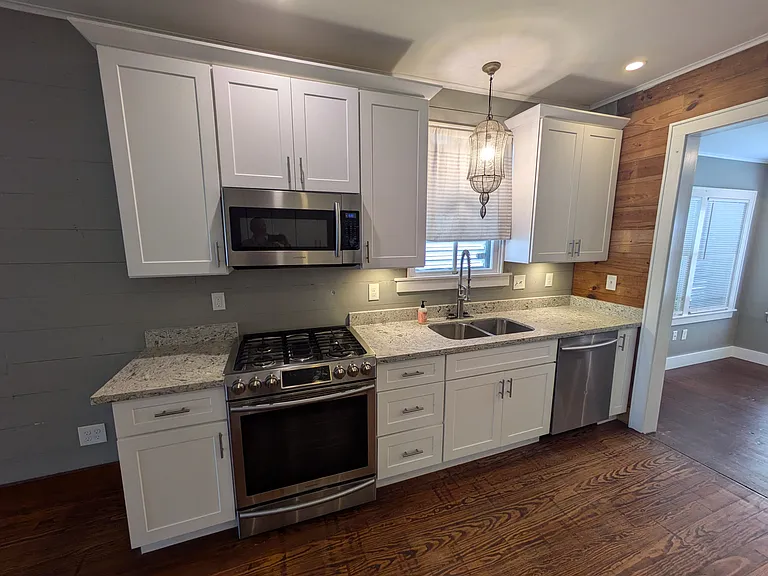Kitchen has premium Samsung slide in gas range w/ large, vented microwave, 3-rack dishwasher and double basin sink with goose neck faucet. Great for chefs!