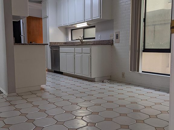 kitchen with stainless fridge, electric glass cooktop and dishwasher