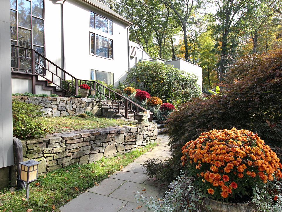 Blau House at 8 Bayberry Ridge is A spacious Mid Century Modern home, suffused with natural light and surrounded by professionally manicured gardens.